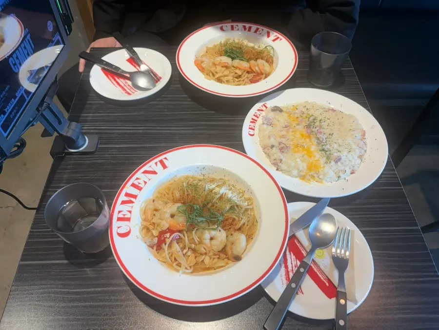 Table setting with shrimp oil pasta and bacon cream cheese risotto