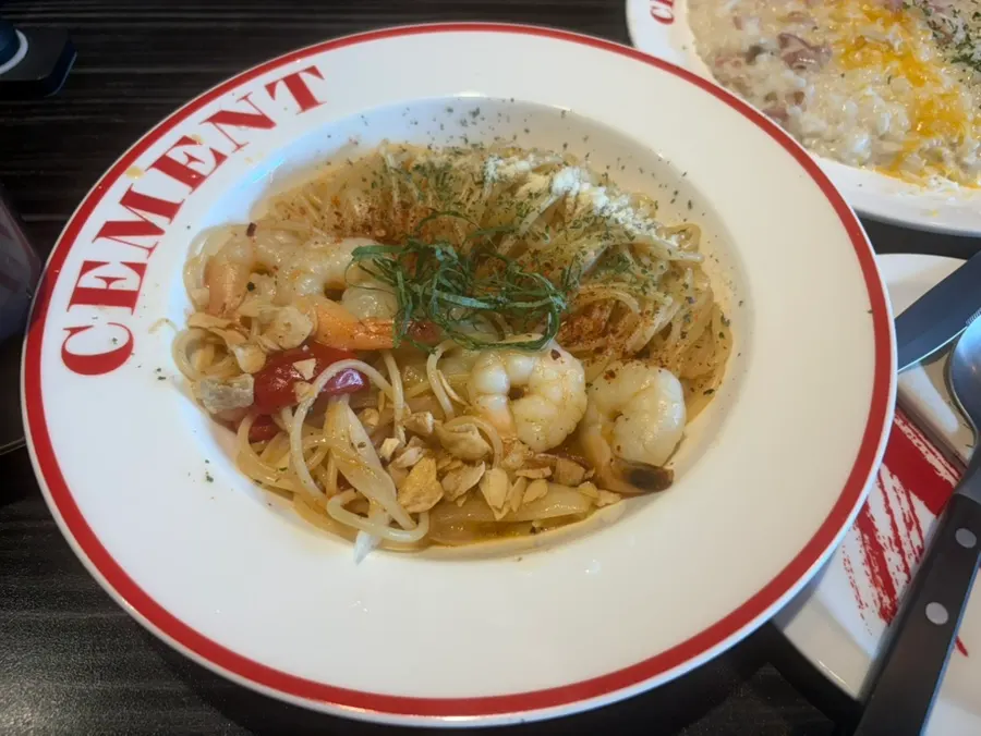 Two plates of shrimp oil pasta ordered as the same dish