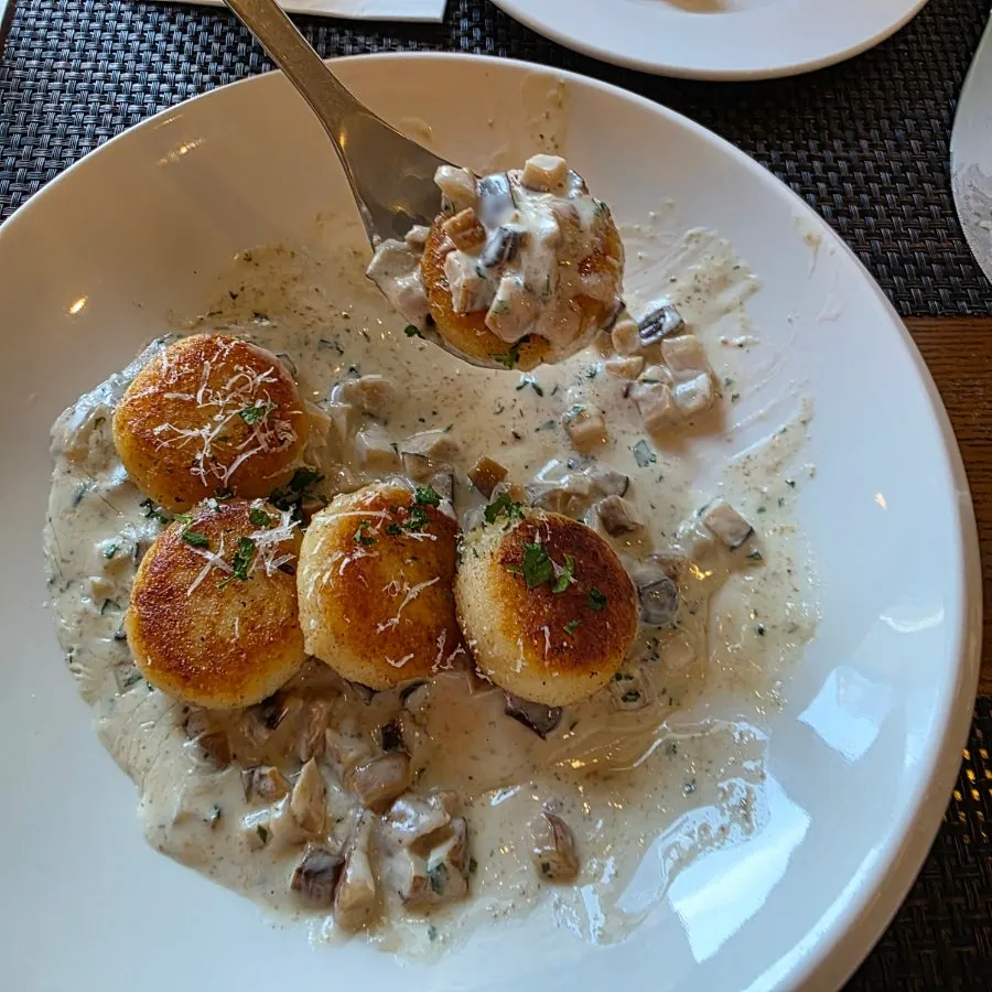 A bite of creamy gnocchi topped with mushrooms