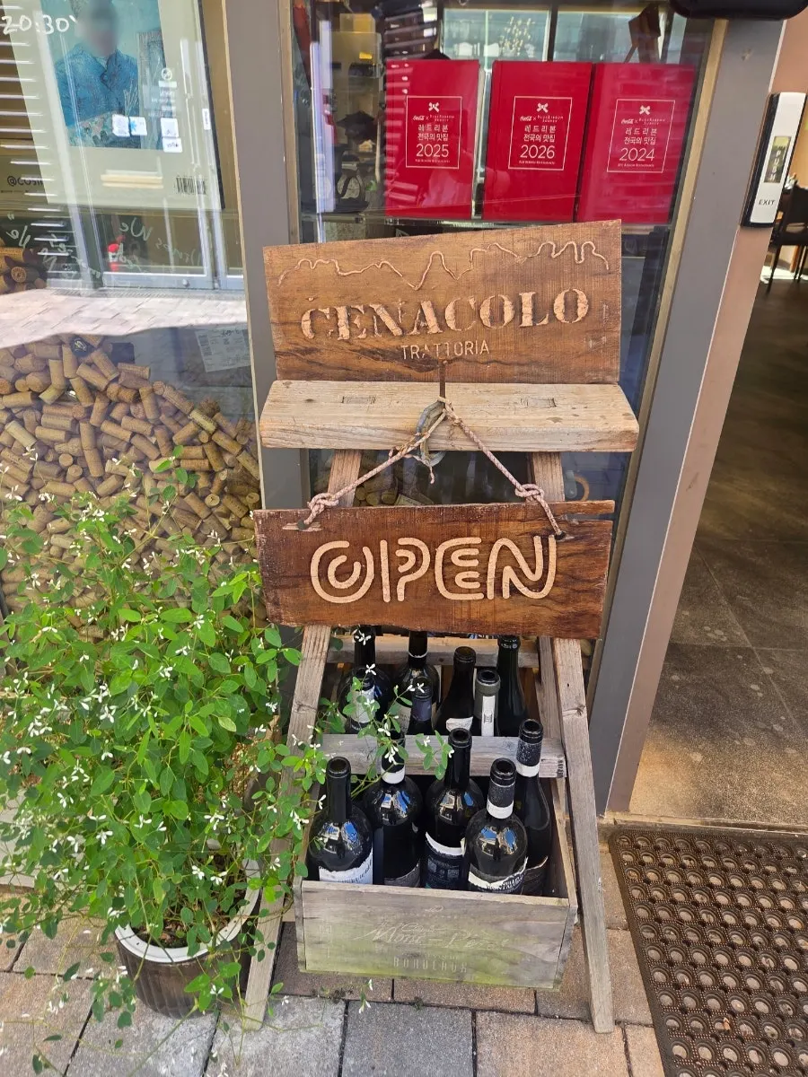 Cenacolo's sign on the red brick exterior