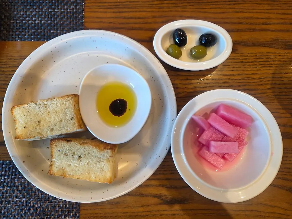 Bread, olives, and pickles set on the table
