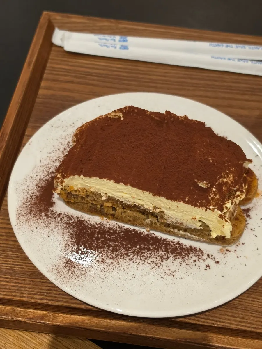 Cross-section of moist tiramisu scooped with a fork
