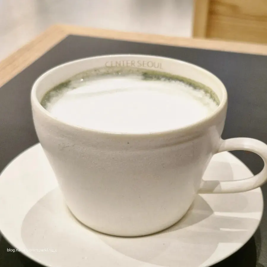 Warm mugwort latte topped with whipped cream