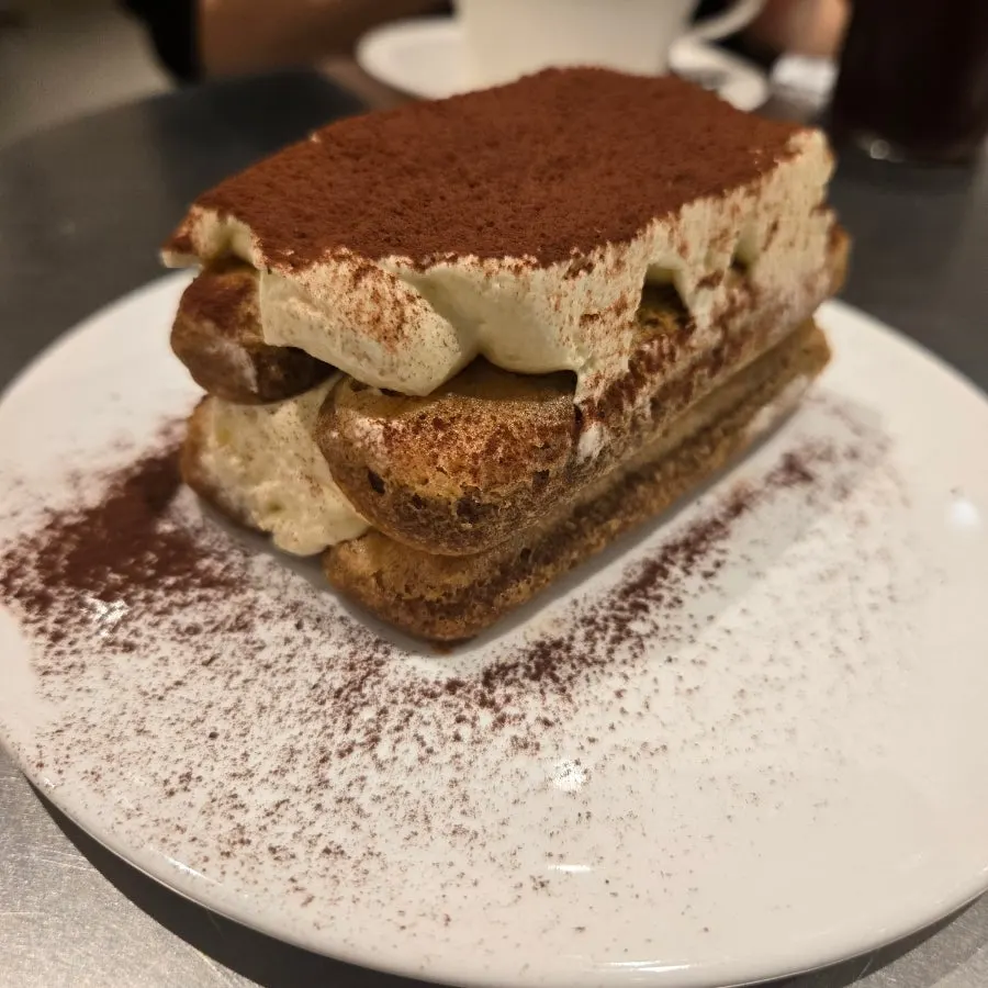 Cross-section of tiramisu topped with mascarpone cream