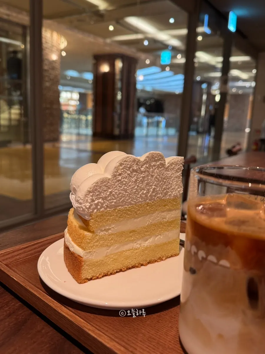 커피와 함께 놓인 생크림 케이크 접시