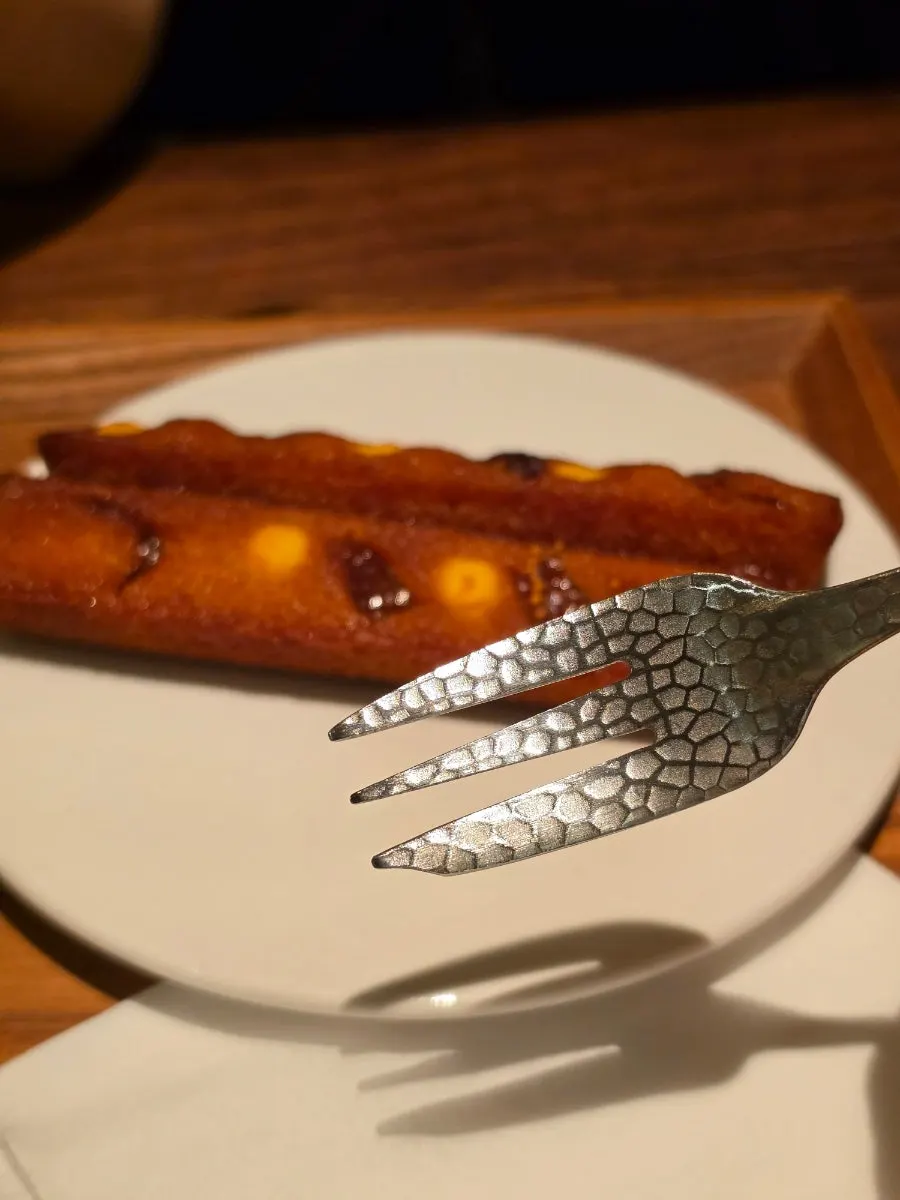 An unusually shaped fork served with dessert