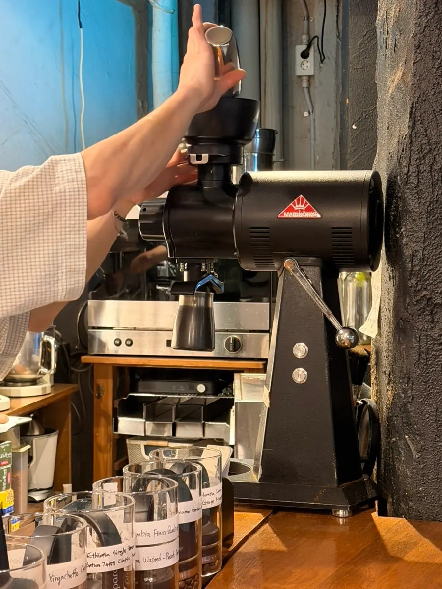 Smelling freshly ground coffee beans from the grinder
