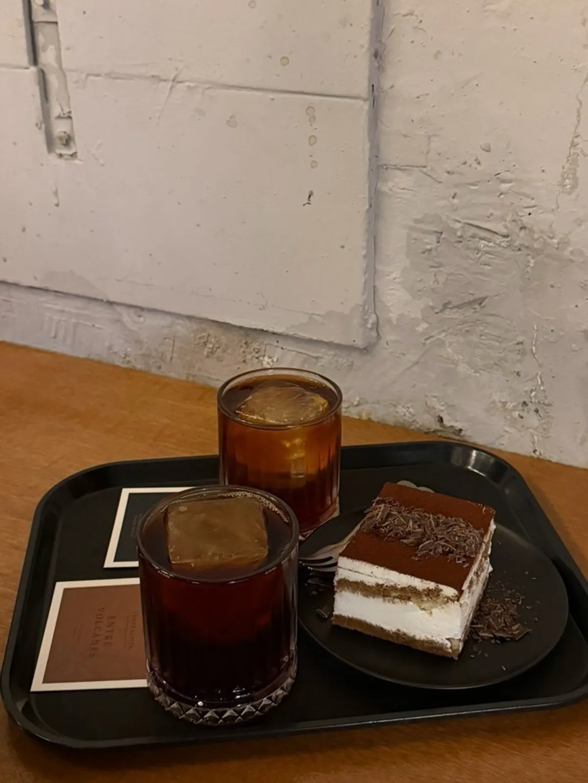 Two drip coffees and a plate of tiramisu