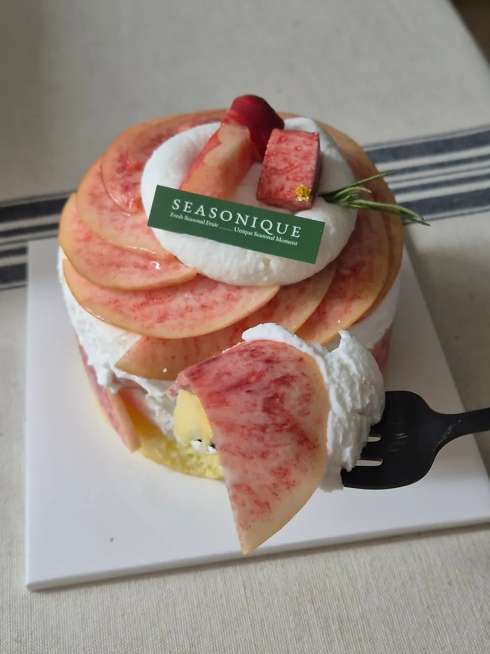 A cut slice of yogurt whipped cream peach cake