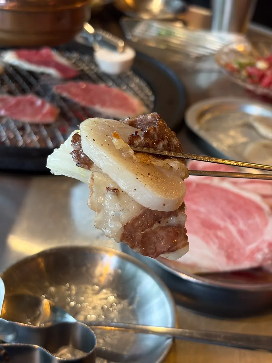 A wrap of baek-kimchi topped with scallop and brisket