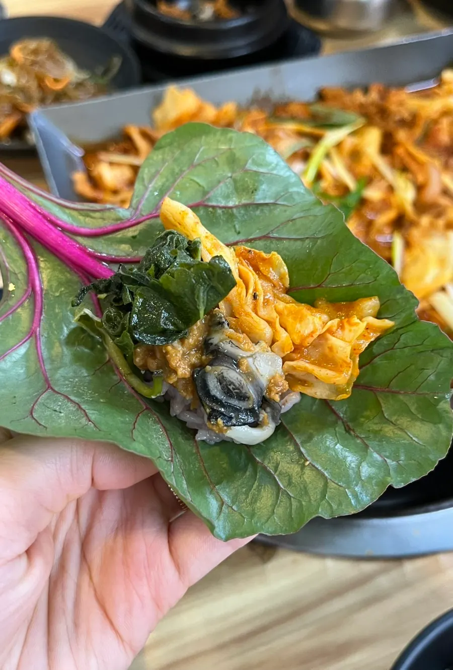 A wrap topped with pork and ureong ssamjang
