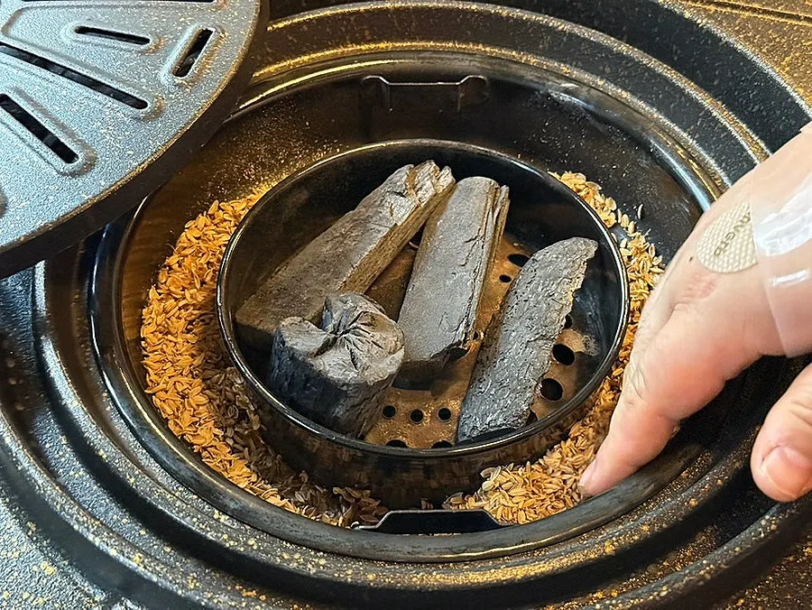 Sign explaining rice-husk smoking and charcoal grilling