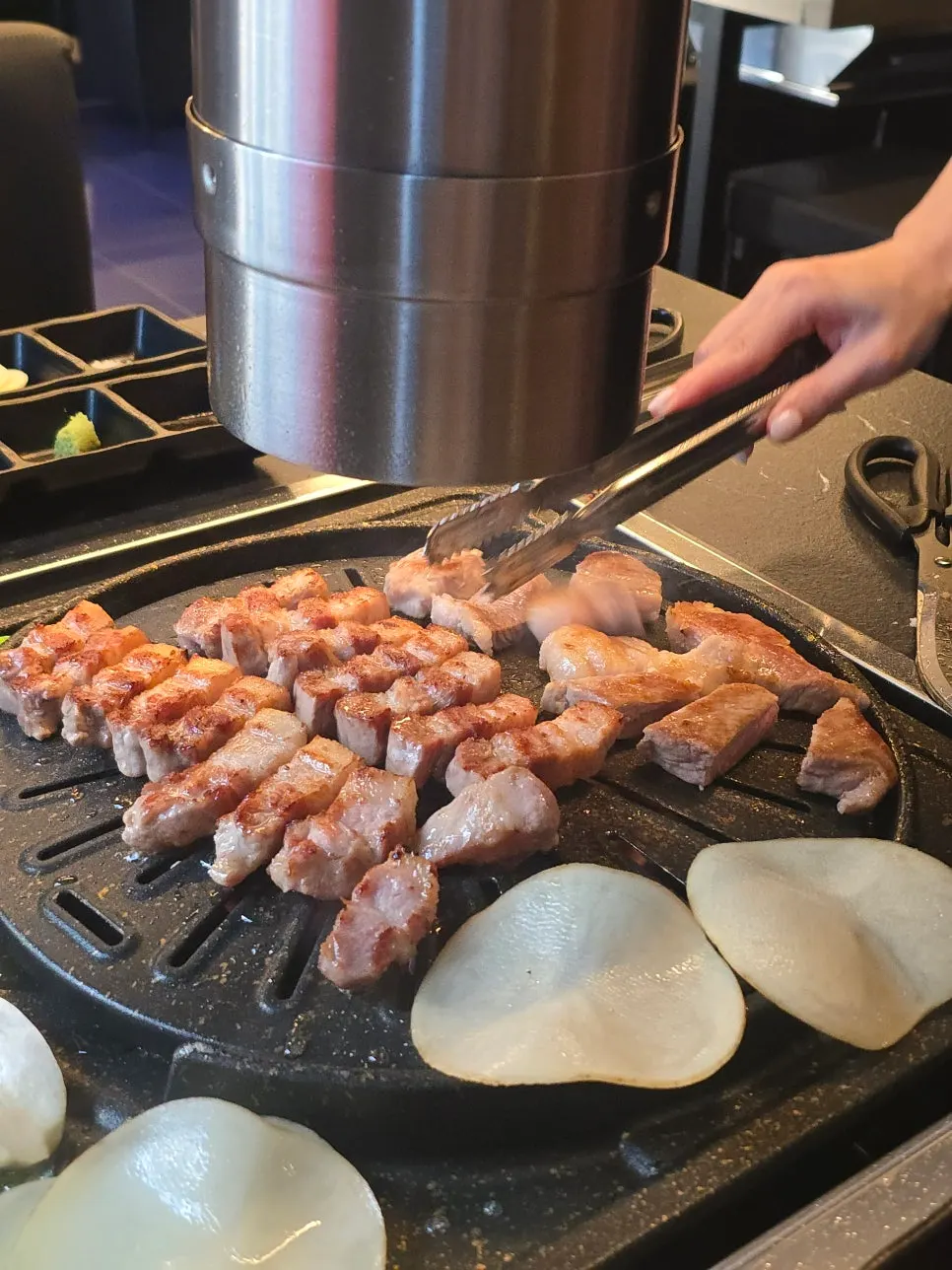 Staff member grilling meat on the pan