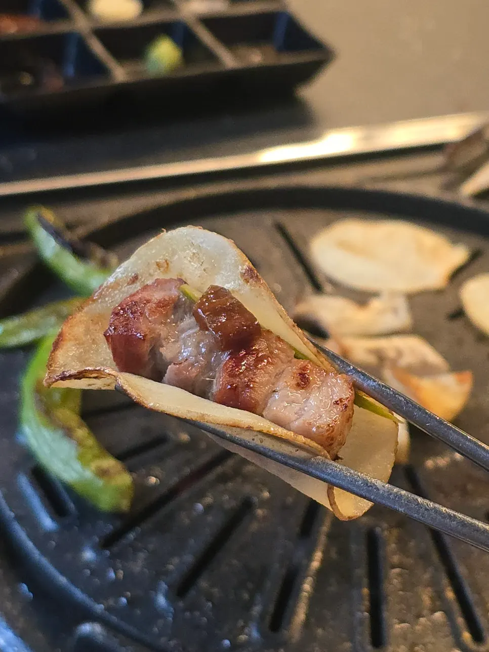 A potato wrap topped with mushroom wasabi and garlic scapes