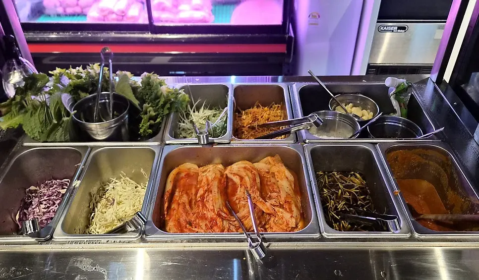 Basic side dishes at Cham Dwaejitgan, including pickled garlic stem