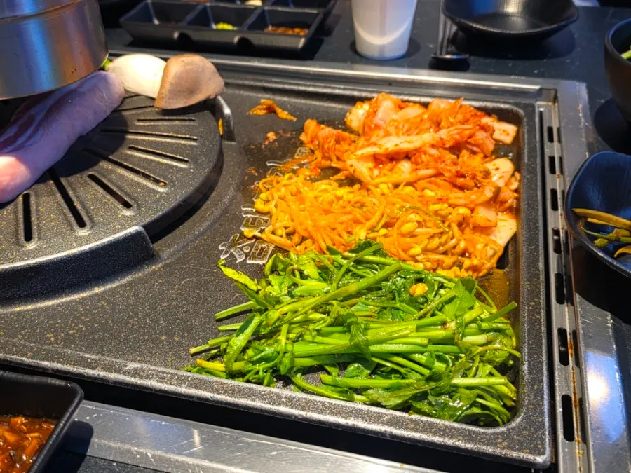 Pork belly and grilled kimchi cooking on the grill