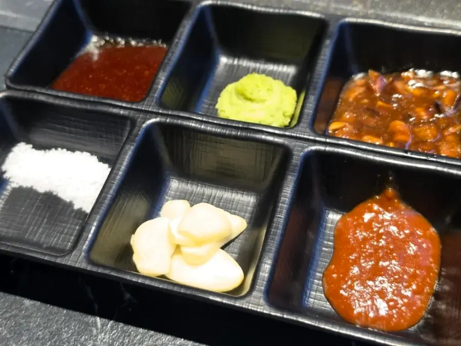 Dishes of ssamjang, spicy sauce, salt, and wasabi