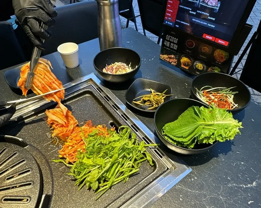 Basic table setting with minari, bean sprouts, kimchi and lettuce wraps
