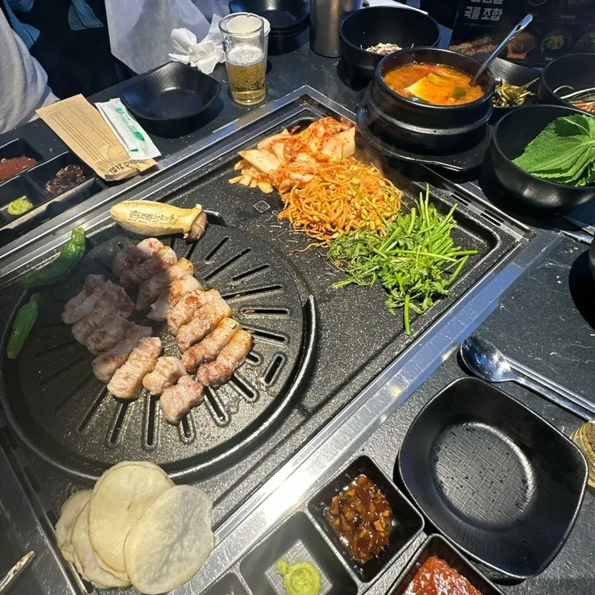 A full spread of grilled pork belly and doenjang jjigae