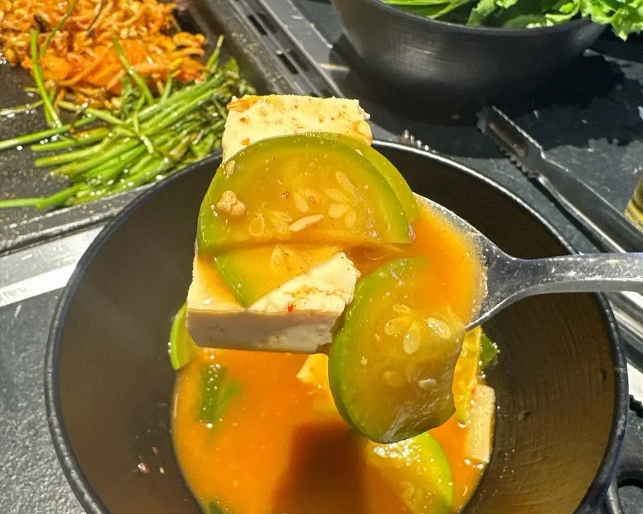A spoonful of doenjang jjigae eaten alongside the pork belly