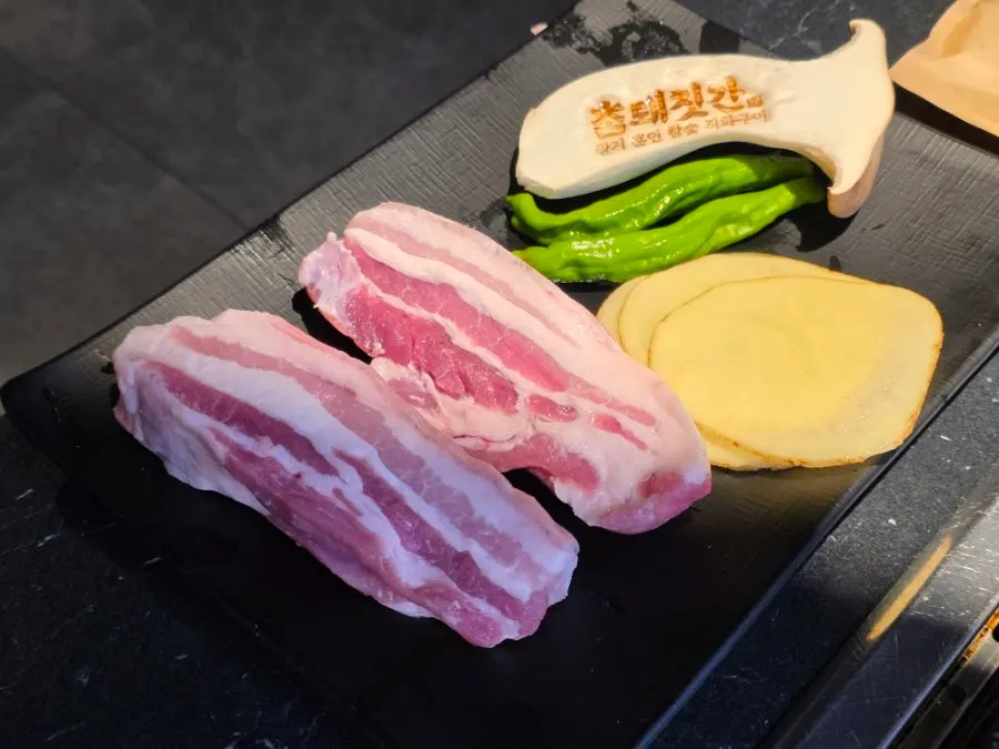 Plate of raw Jeju black pork, 2 servings, at Cham Dwaejitgan