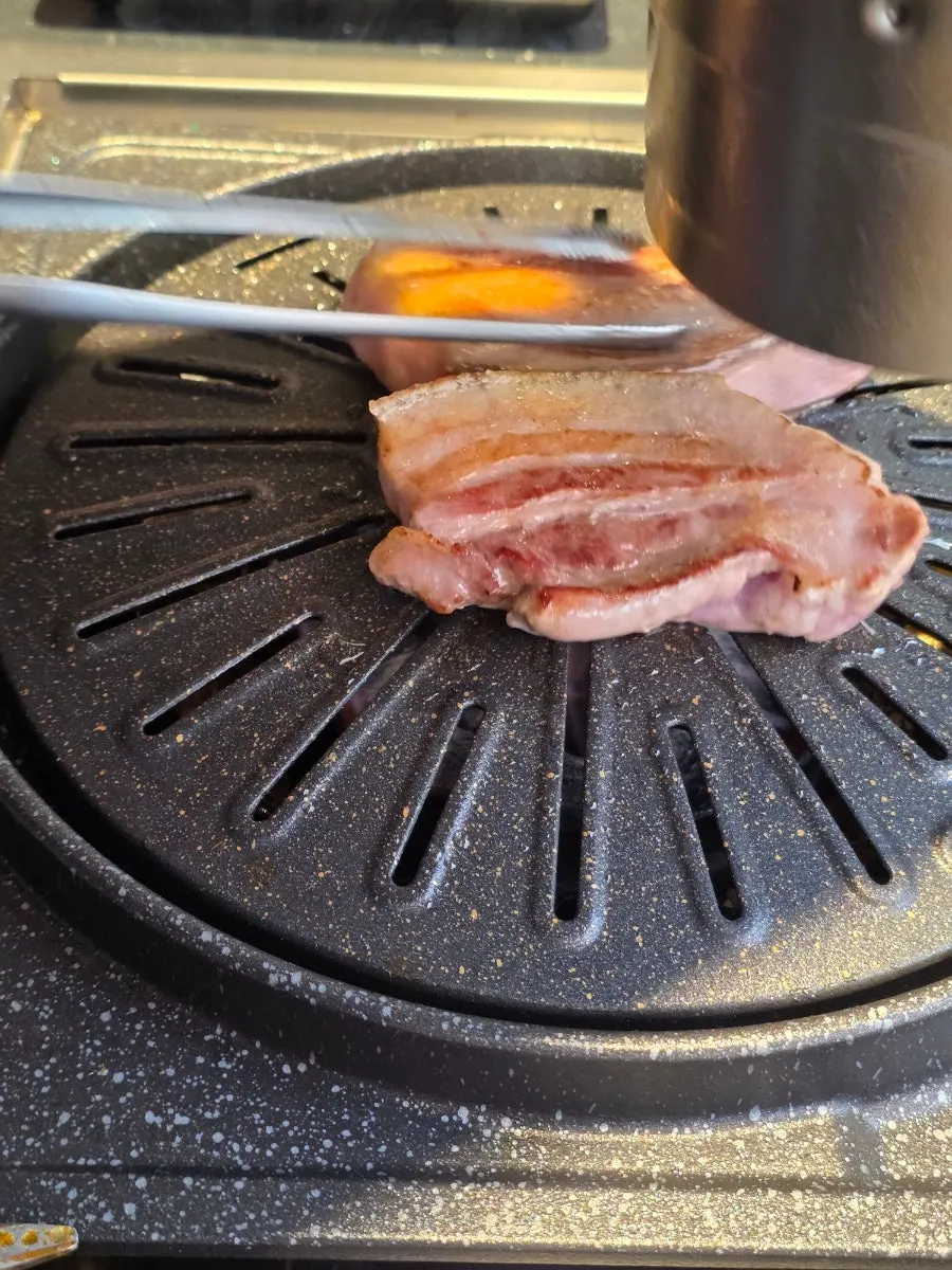 Staff grilling all four sides of the thick-cut black pork