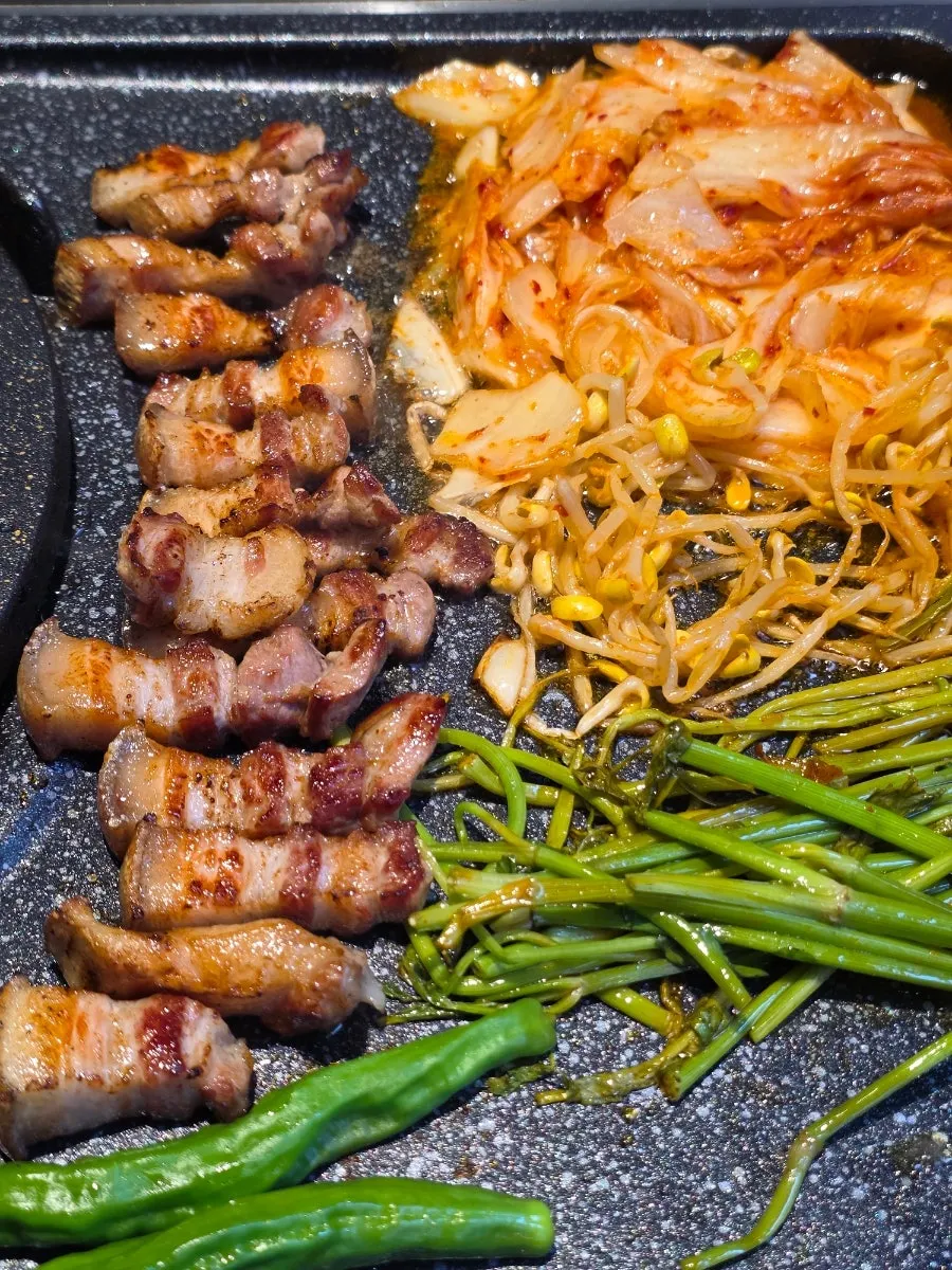 Golden-fried kimchi alongside cooked black pork