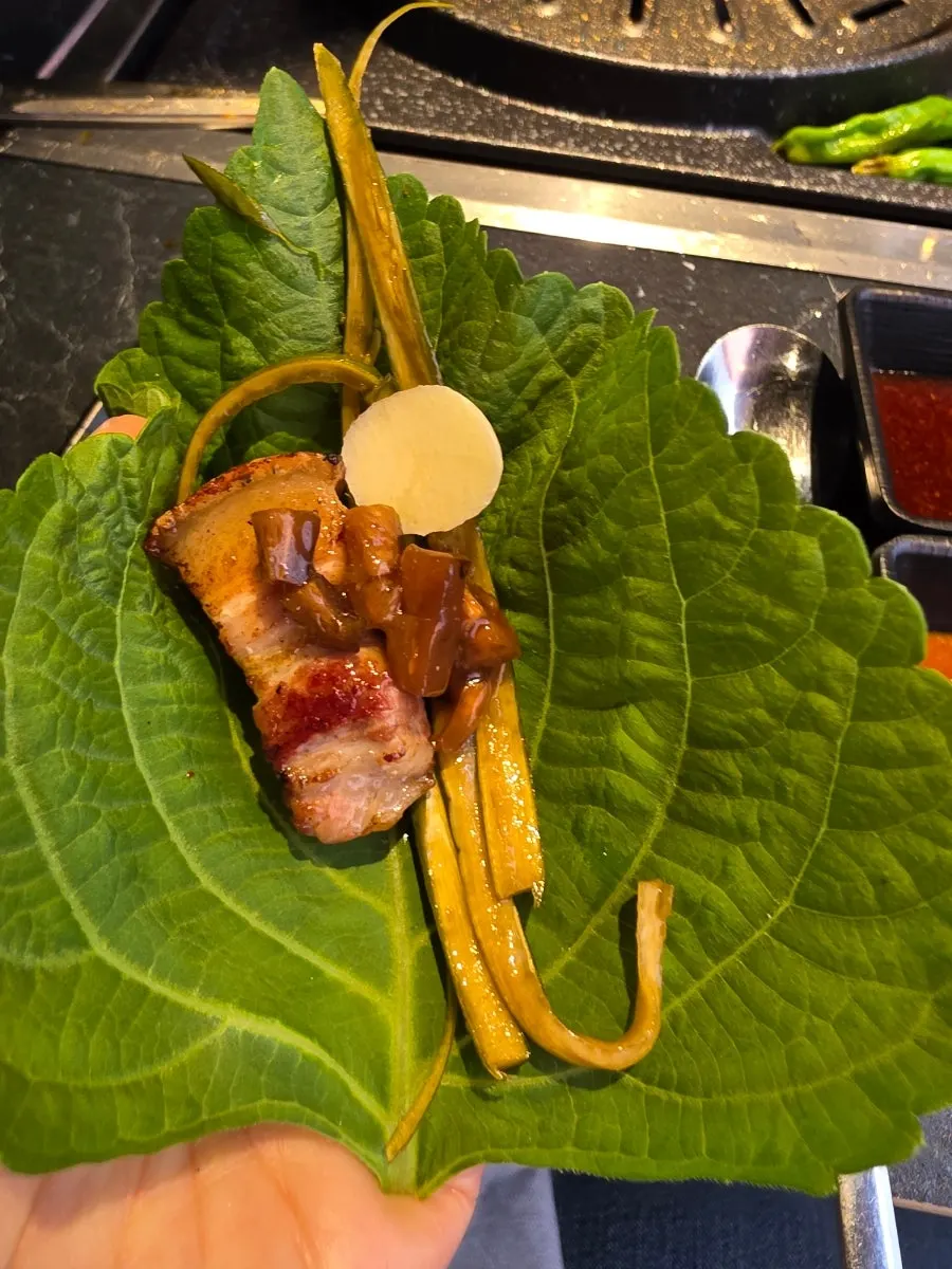 A bite of potato wrap filled with meat and vegetables
