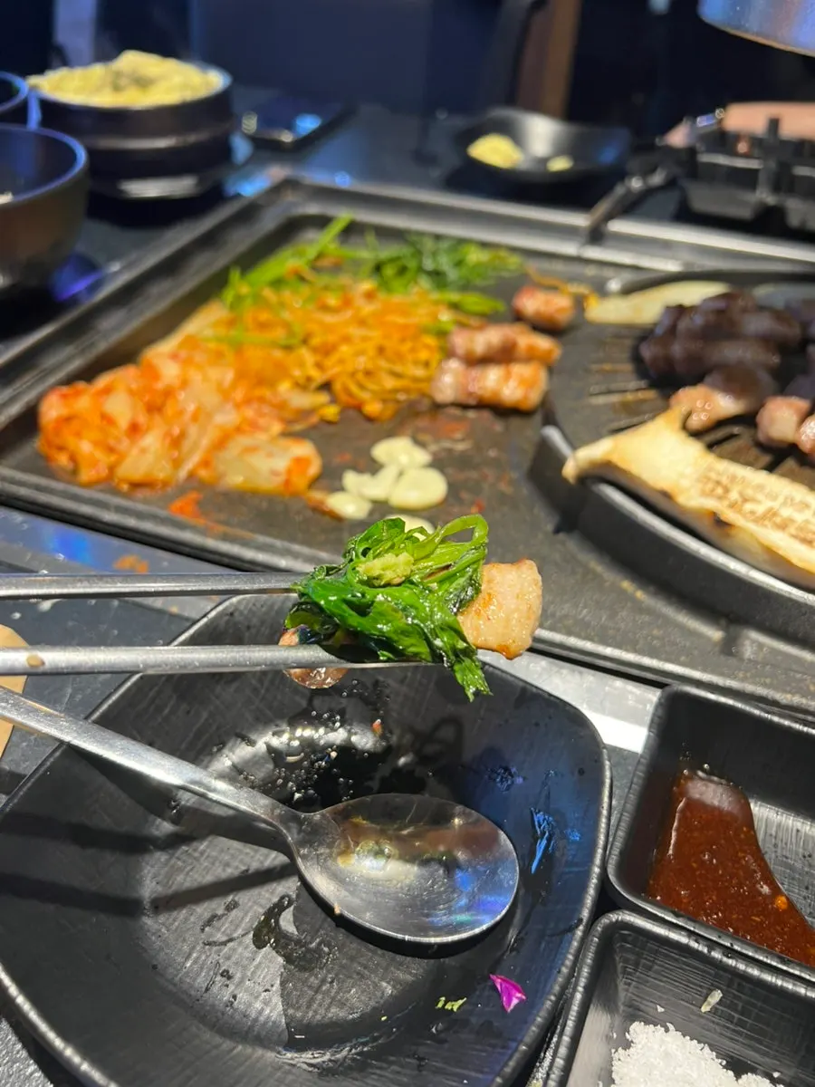 삼겹살과 곁들임이 함께 놓인 불판