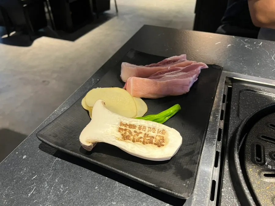King oyster mushroom stamped with the Cham Dwaejitgan logo alongside side vegetables
