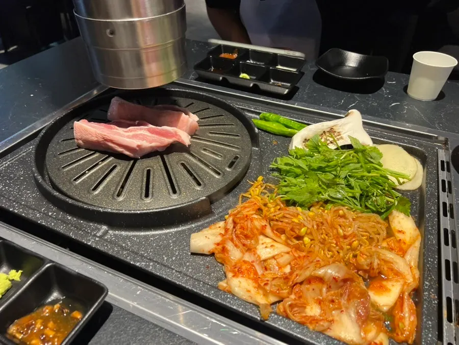 Thick ogyeopsal grilling alongside vegetables