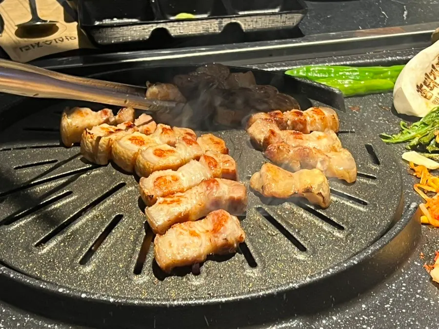 Ogyeopsal cut into bite-sized pieces and lined up neatly on the grill