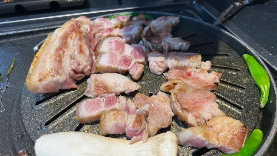 직원이 직접 구워주는 오겹살 그릴링 장면