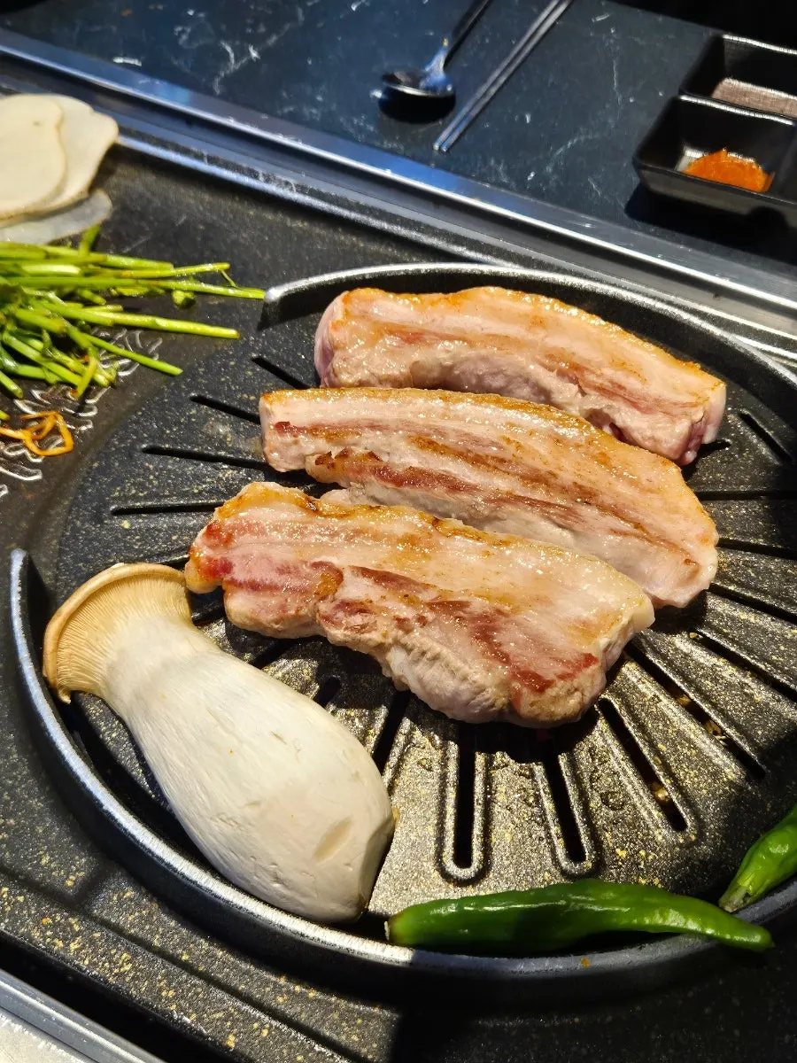 Sliced potato and mushrooms served alongside the pork belly