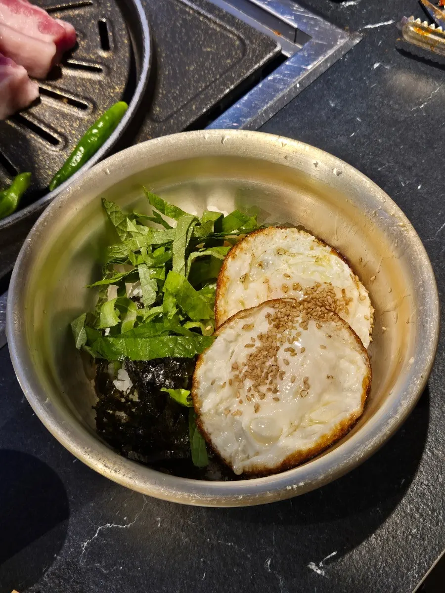 A bite of pork belly wrapped in a potato slice