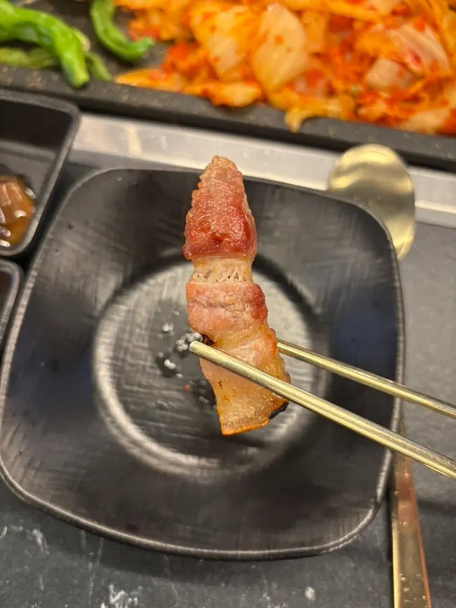Potato slices added to the grill alongside the meat