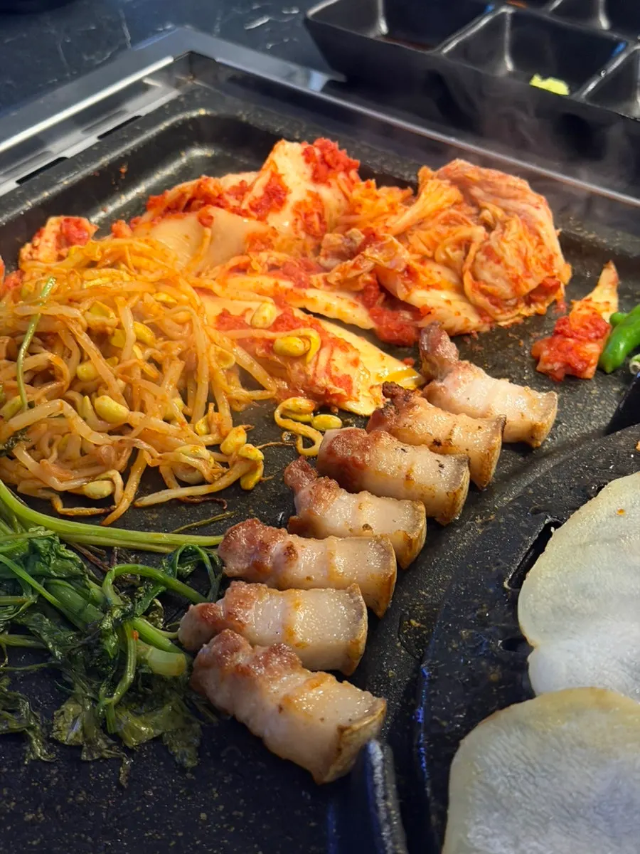 두툼하게 구워진 흑돼지 오겹살 한 점