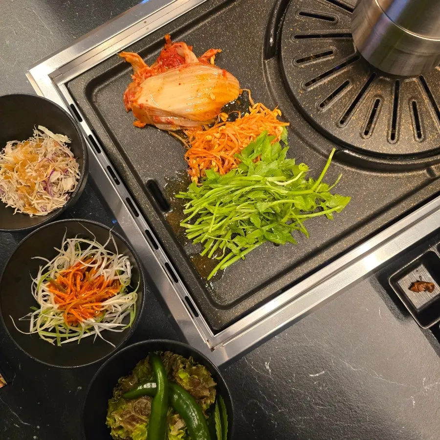 Basic side dishes at Cham Dwaejitgan: kimchi, bean sprouts, minari