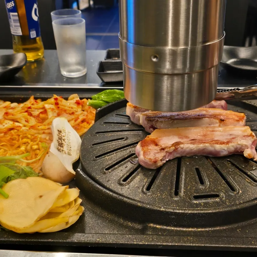 Staff member grilling pork belly on the grill
