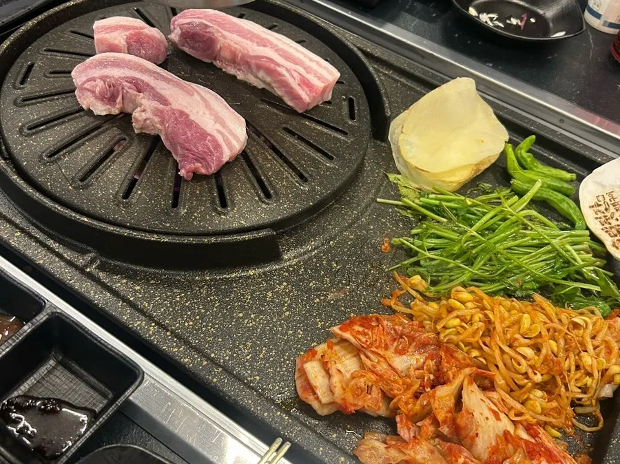 불판 위 미나리와 함께 익는 고기