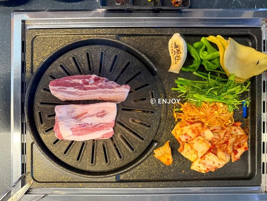 Minari, bean sprouts and grilled kimchi on one side of the pan