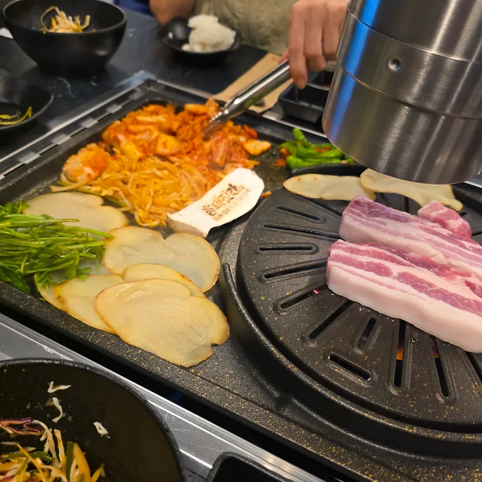 焼けていくキューブ状のサムギョプサルとセリ