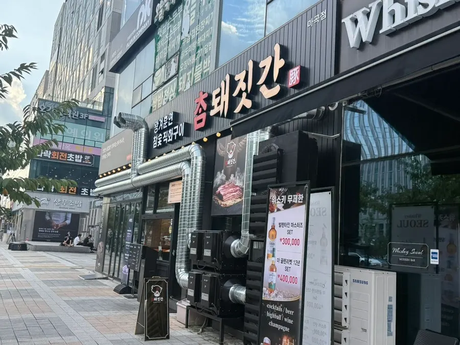 검정색 간판과 연통이 있는 참돼짓간 마곡점 외관