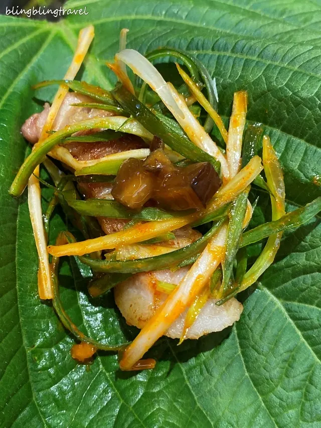 깻잎에 삼겹살과 파채를 올린 쌈