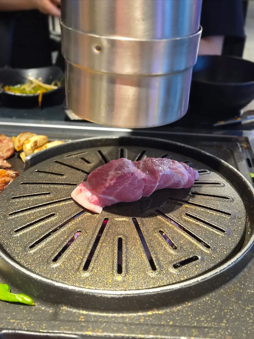 A piece of grilled pork belly placed in a lettuce wrap