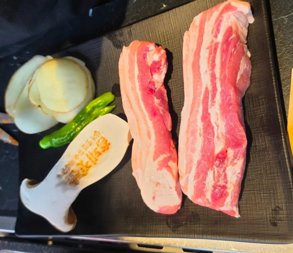 두툼하게 썰린 흑돼지 오겹살과 감자 버섯