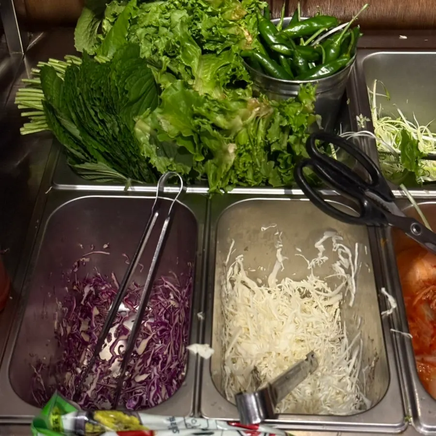Table setting with wrapping vegetables and pickled garlic scapes