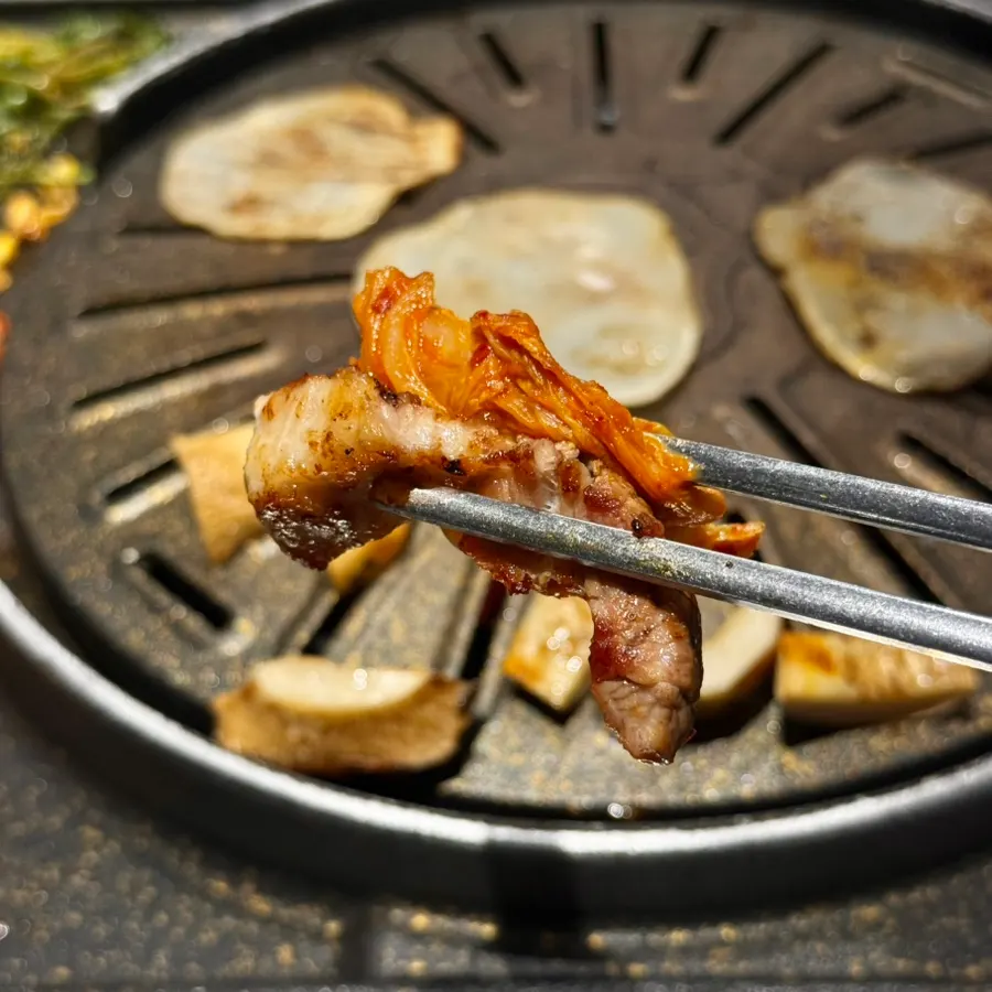 Kimchi and pork belly grilling together on the pan