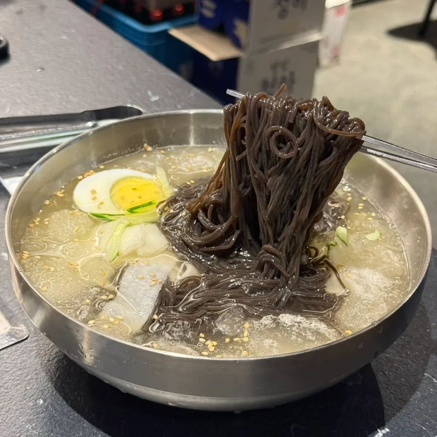 Chewy kalchi noodles lifted from the cold noodle bowl