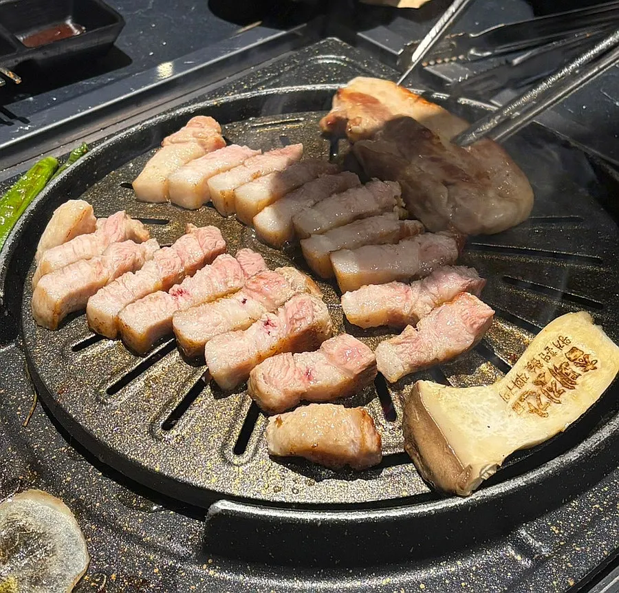 Pork belly grilling on the chaff grill